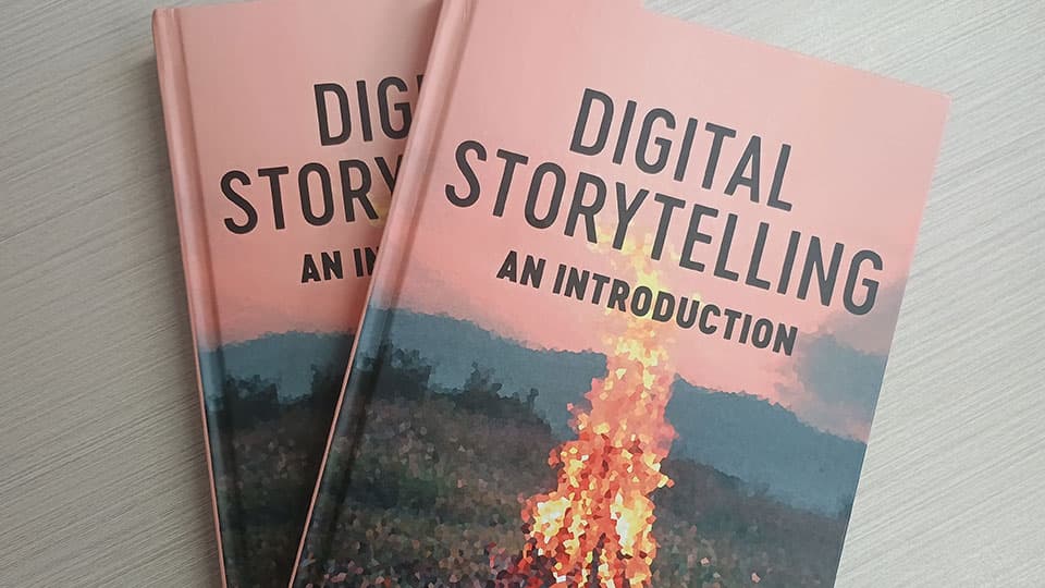 Two copies of Leah Henrickson's book overlapping each other. A digital image of a fire with text that reads Digital Storytelling: An introduction